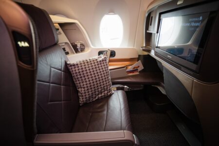 Premium business class seat with pillow and in-flight screen for performance travel